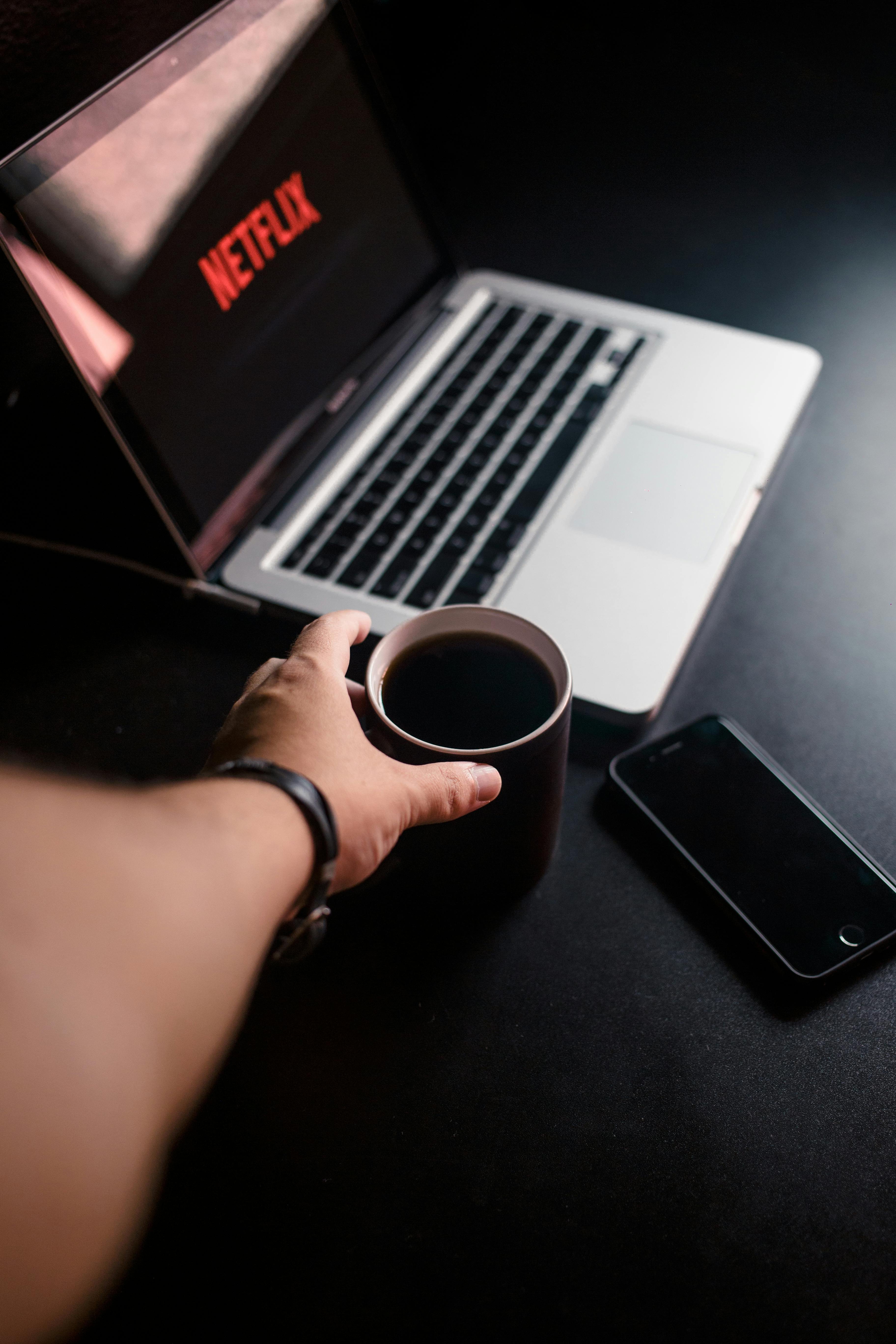Personne regardant un film sur un ordinateur portable illustrant la critique cinéma à l’ère du streaming et de la diversité
